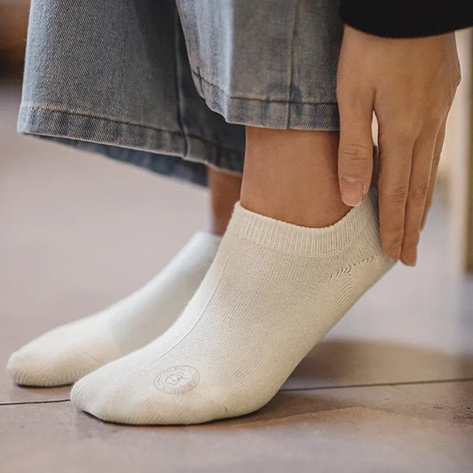Person wearing beige ankle socks with a blurred background